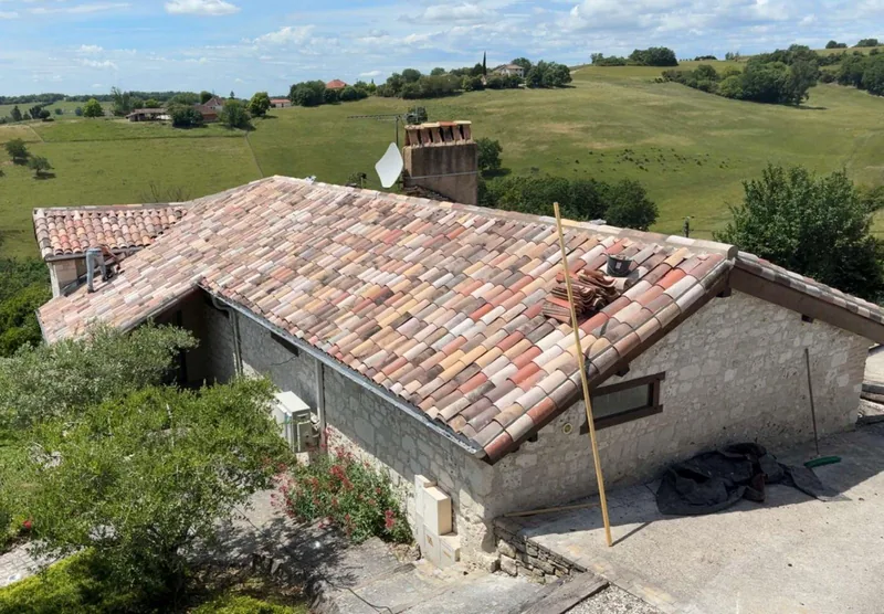 Toiture de ferme en tuiles rénovée, entourée d’oliviers