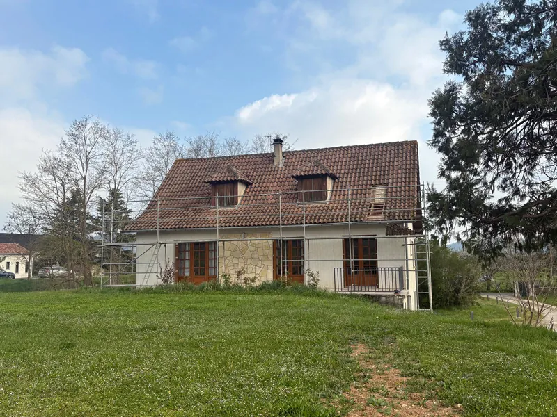Maison en pierre avec toiture en tuiles et échafaudage installé